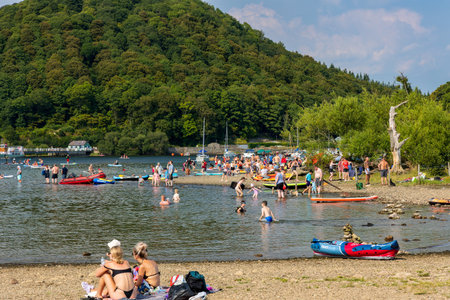 ULLSWATER, ENGLAND - AUGUST 14 2023 - Crowds of people with swimmers on the shores of Ullswater in the English Lake District in summerのeditorial素材
