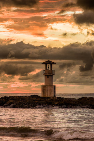 Colorful tropical sunset behind a small lighthouse (Khao Lak, Thailand)の写真素材