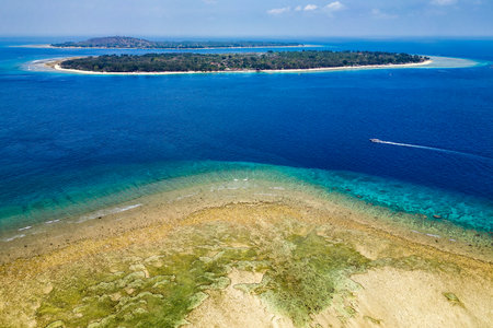 Aerial view of a reef table and coral reef off a tiny tropical islandの写真素材