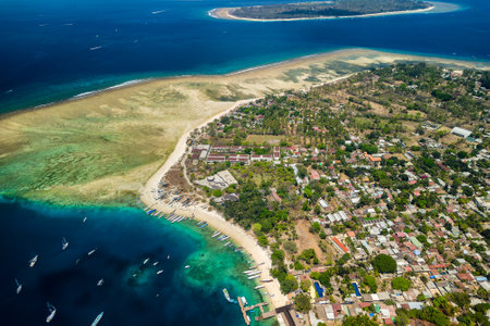 Aerial view of a tiny tropical island surrounded by large, fringing coral reef and blue, warm ocean (Gili Air, Lombok, Indonesia)の写真素材