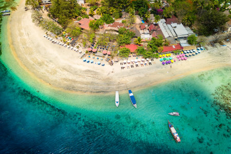 Aerial view of a tropical beach resort next to a coral reef on a small island (Gili Air, Indonesia)の写真素材