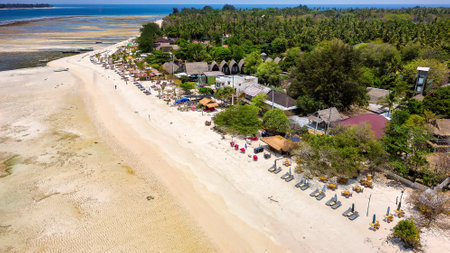 Colorful sunshades, lungers and seats on a sandy tropical beach on a small island (Gili Islands, Indonesia)の写真素材
