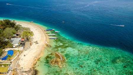 Aerial view of tourist boats over the coral reef flat on a small tropical islandの写真素材