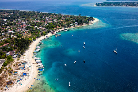 Aerial view of lines of wooden tourist boats on a sandy beach of a tropical islandの写真素材