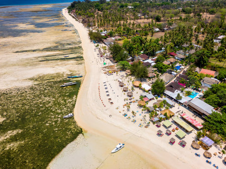 Aerial view of colorful sun loungers and parasols on a small tropical beach (Gili Islands, Lombok, Indonesia)の写真素材