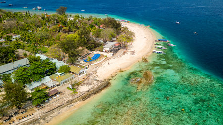 Aerial view of tourist boats over the coral reef flat on a small tropical islandの写真素材