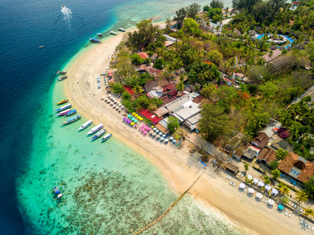 Aerial view of colorful sun loungers and parasols on a small tropical beach (Gili Islands, Lombok, Indonesia)の写真素材