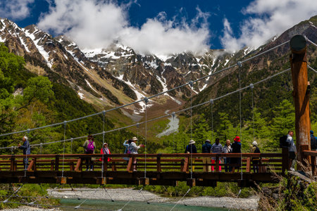 KAMIKOCHI, JAPAN - MAY 24 2023: Crowds of hikers and tourists on the Kappa Bridge over the Azusa river in the beautiful Kamikochi valley in Nagano prefectureのeditorial素材