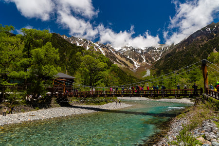 KAMIKOCHI, JAPAN - MAY 24 2023: Crowds of hikers and tourists on the Kappa Bridge over the Azusa river in the beautiful Kamikochi valley in Nagano prefectureのeditorial素材