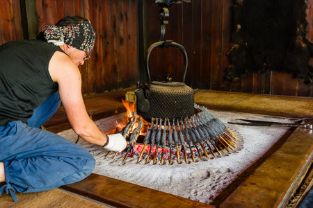 KAMIKOCHI, JAPAN - MAY 24 2023: Traditional Japanese Iwana fish (Grilled Char) being prepared in a mountain lodge in the Kamikochi Valley, Nagano, Japanのeditorial素材