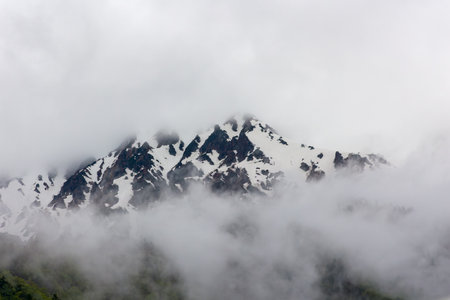 Clouds over jagged snow-covered peaks of the northern Japanese Alps