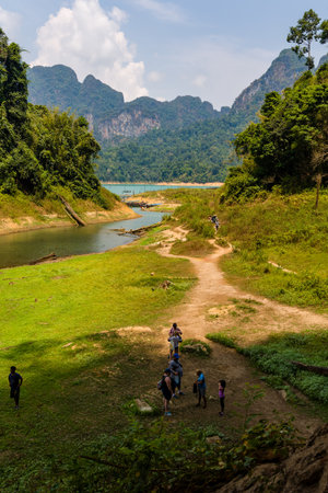 KHAO SOK, THAILAND - APRIL 02 2024:- Hikers and tourists exploring the tropical rainforest and karst...