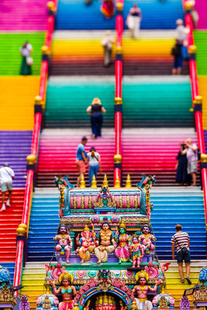 KUALA LUMPUR, MALAYSIA - APRIL 12 2024: Crowds of people ascending the brightly colored staircase at...