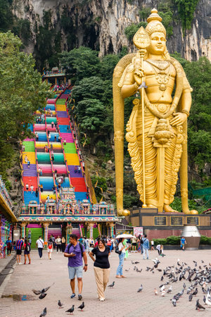KUALA LUMPUR, MALAYSIA - APRIL 12 2024: Worshippers and tourists on the brightly colored steps of the Batu Caves at the Hindu religious site outside Kuala Lumpurのeditorial素材