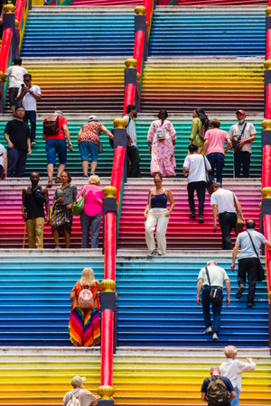 KUALA LUMPUR, MALAYSIA - APRIL 12 2024: Worshippers and tourists on the brightly colored steps of...