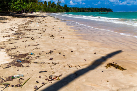 Plastic bottles and other pollution washed up onto a tropical beach by the tide  in asiaの写真素材
