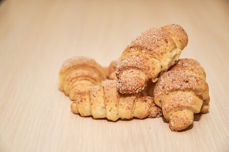 freshly baked croissants on a light wooden table