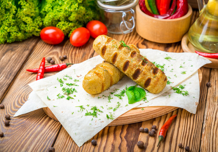 Grilled sausages with sauce on a wooden tableの写真素材