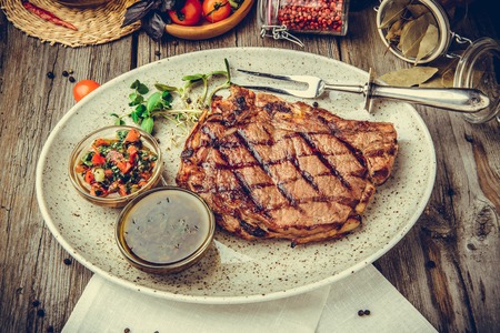 Grilled steaks, steak on a plate, on a wooden backgroundの写真素材