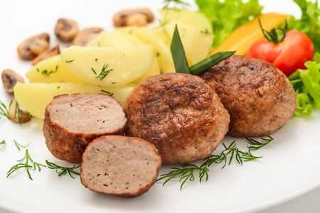 Homemade cutlets with potatoes and vegetables on a white background. Healthy food