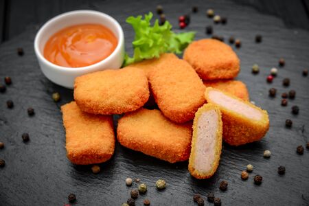 fast food chicken nuggets with ketchup, against a dark backgroundの写真素材