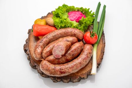Home-made sausage with vegetables on a wooden boardの写真素材