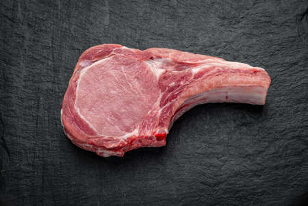 Fresh, raw pork steak on a dark background