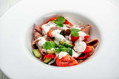 Beef tongue salad with fresh vegetables. Serving food in a restaurant. Photo for the menuの写真素材