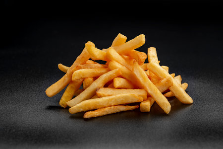 Pile of french fries over black background. Photo for the menuの写真素材