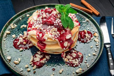 Pancake tower with yogurt, nuts and cherry jam. Healthy and wholesome food. Serving food in a...