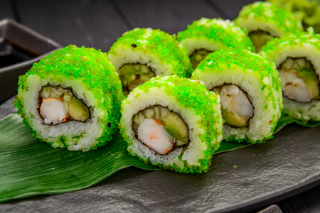 Traditional delicious fresh sushi roll set on a black background. Sushi roll with rice, nori, cream cheese, tobiko caviar, avocado. Sushi menu. Japanese kitchen, restaurant. Asian foodの写真素材