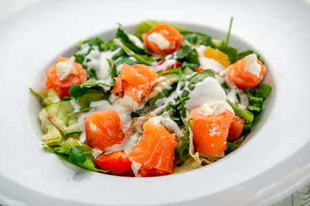 Salad with smoked salmon, fresh vegetables and cream cheese. Serving food in a restaurant. Photo for the menuの写真素材