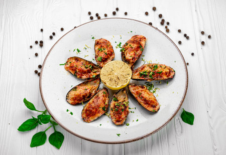 Baked mussels with cheese on plate. Mussels baked in shells with cheese and garlic. Serving food in a restaurant. Photo for the menuの写真素材