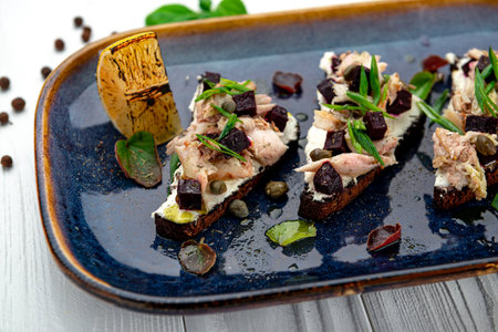 Toast with tuna. Italian Appetizer bruschetta, sandwiches with canned tuna, green onions and beetroot. Serving food in a restaurant. Photo for the menuの写真素材