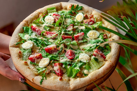 Homemade pizza with Caesar salad, an interesting serving of salad with chicken meat. Photo of pizza menuの写真素材