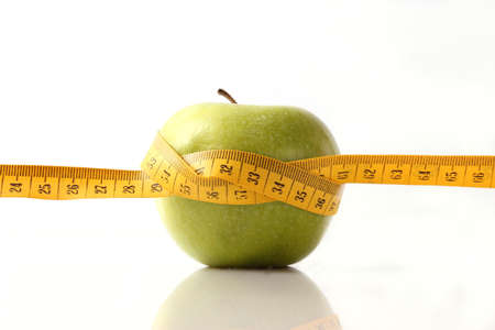 apple and measuring tape close-up on a light background