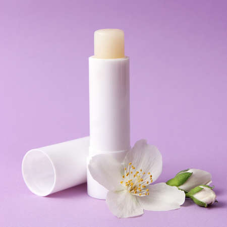 lip balm and flowers on a colored background close-up