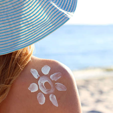 Young woman on the beach uses sunscreen.の写真素材