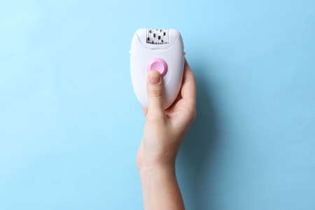 Modern mechanical epilator on a colored background