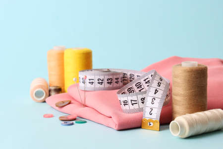 Set of different sewing accessories on a colored background close-up
