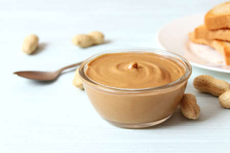 creamy peanut butter and peanuts beans on wooden background top viewの写真素材