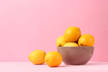 lemons and green leaves on a colored background.の写真素材