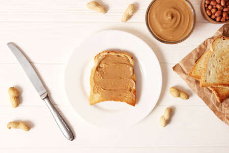 creamy peanut butter and peanuts beans on wooden background top viewの写真素材