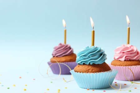 Delicious cupcake with a candle on a colored backgroundの写真素材