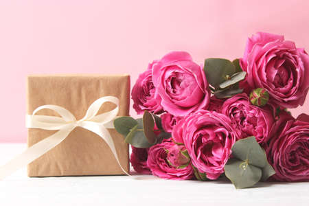 gift and flowers on a colored background. Holiday, give a gift, congratulationsの写真素材