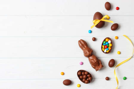 Easter composition with chocolate eggs and chocolate rabbit on wooden backgroundの写真素材
