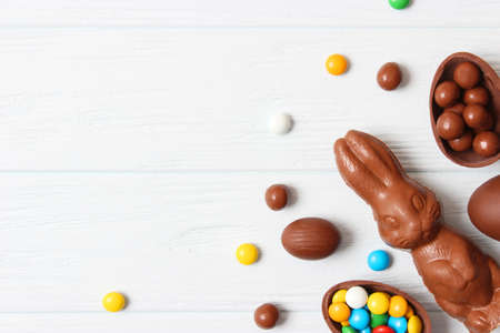 Easter composition with chocolate eggs and chocolate rabbit on wooden background