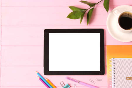 Modern digital tablet and school stationery on a colored background top view.