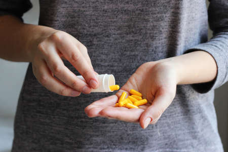 Medical pills in female hands. Take pills. Vitamins, food additives.
