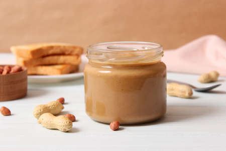 creamy peanut butter and peanuts beans on wooden background top viewの写真素材